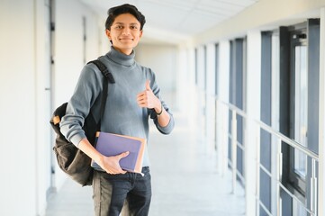 A professional carrying a backpack and holding a laptop in a bright corridor - 3webindia.com